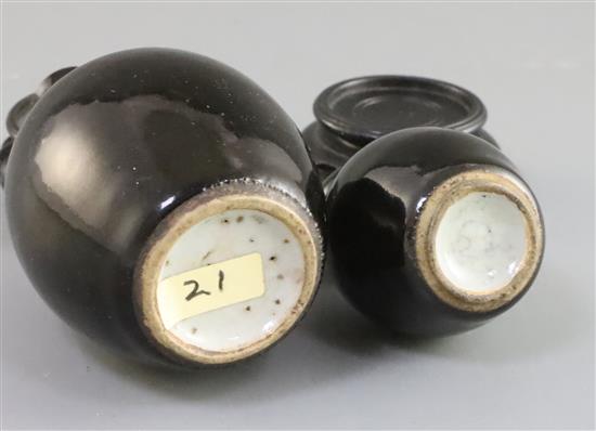 Two Chinese miniature black glazed double gourd vases, 18th century, H. 9.5cm and 7.4cm, tiny rim chip, wood stands